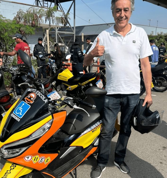 Aluno aprovado da Anhembi Auto Escola segurando a placa de aprovação