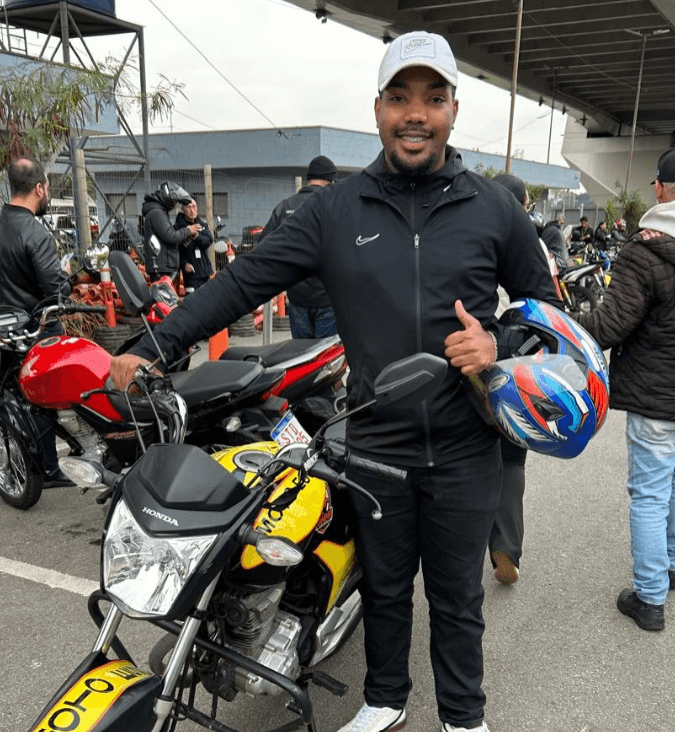 Aluno aprovado da Anhembi Auto Escola segurando a placa de aprovação