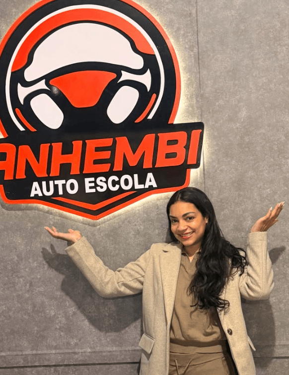 Aluno aprovado da Anhembi Auto Escola segurando a placa de aprovação